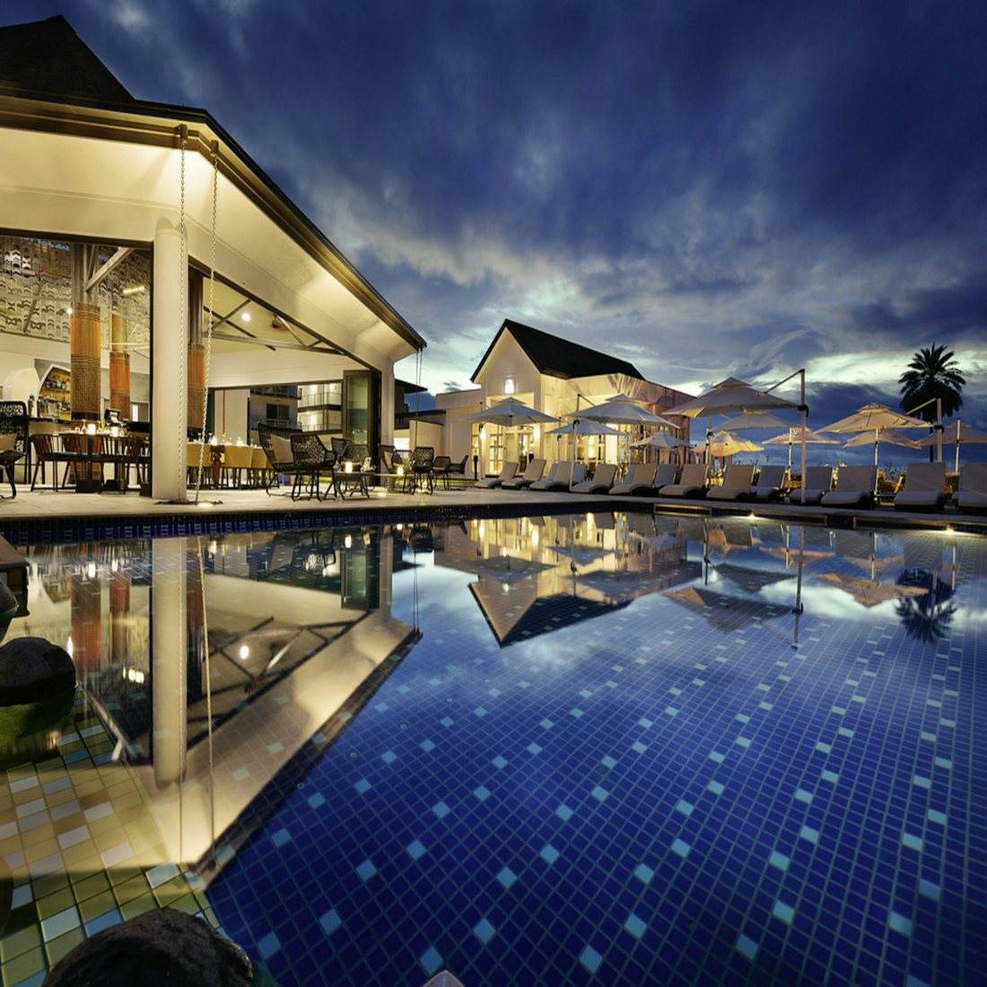 Staffed villa pool at night (representative)